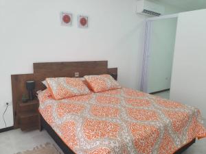 亚松森Departamento 1 habitación zona exclusiva的一间卧室配有一张带橙色和白色棉被的床