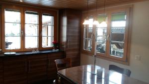格林德尔瓦尔德巴格布里克木屋酒店的厨房配有木制橱柜、桌子和窗户。