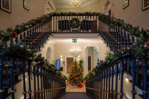 伦敦兰斯伯里文物酒店的室内楼梯,带圣诞装饰品和圣诞树