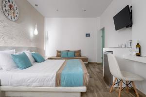 费拉绿洲酒店的一间卧室配有一张床、一张书桌和一台电视