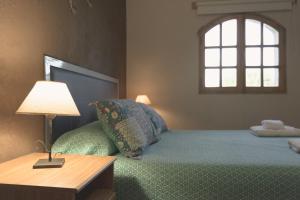圣拉斐尔Apart Hotel La Bodega的一间卧室配有一张带灯和窗户的床