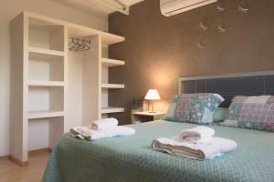 圣拉斐尔Apart Hotel La Bodega的一间卧室配有带毛巾的床