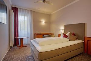 巴特克罗伊茨纳赫维多利亚酒店的酒店客房设有一张大床和一张书桌。