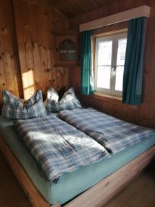 艾奇Berghütte Franz'l的小木屋内的一张床位,设有窗户