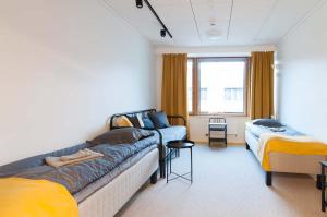 赫尔辛基Moi Aikatalo Hostel Helsinki的客房设有两张床、一张床和窗户。