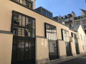 巴黎Hôtel Villa Blomet的街道上设有黑色门窗的建筑