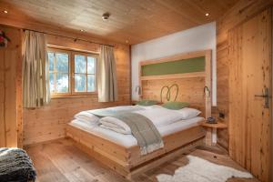 巴特霍夫加施泰因Herzwies的小木屋内一间卧室,配有一张床