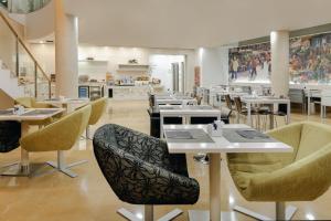 巴塞罗那RAMBLAS HOTEL powered by Vincci Hoteles的一间在房间内配有桌椅的餐厅