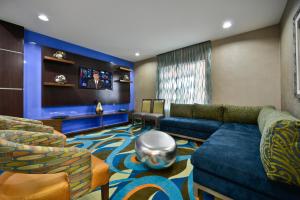 福雷斯特城Holiday Inn Express & Suites Forrest City, an IHG Hotel的客厅配有蓝色的沙发和椅子