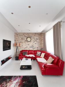 若雷Goldwell Apartments - Szczesliwa的客厅里的一个红色沙发,有砖墙