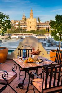 塞维利亚Casa de Triana Luxury Suites by Casa del Poeta的海港景阳台桌子