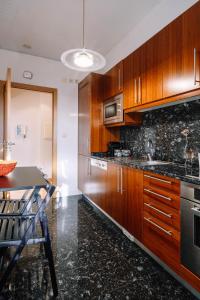 波尔图BBA Apartments Boavista - Casa da Música with Parking的厨房配有木制橱柜和台面