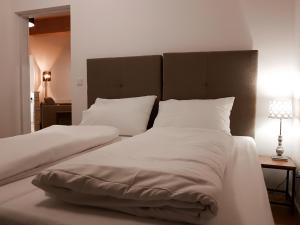 塞默灵Semmering Loft的一间卧室配有两张带白色床单和枕头的床。