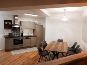 塞默灵Semmering Loft的厨房以及带木桌和椅子的用餐室。