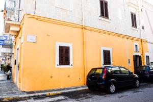 莫诺波利Cuorcuoredicasa的停在黄色建筑前面的汽车