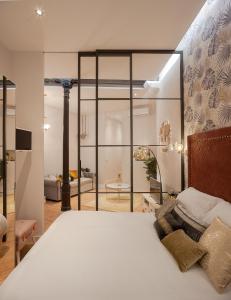 马德里MIMA Suites Chueca的一间带白色大床的卧室和一间客厅