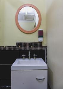 墨尔本Royal Derby Hotel的浴室设有白色水槽和镜子