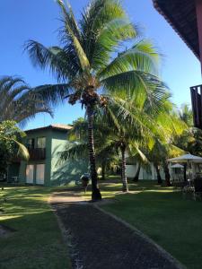 伊塔齐米林Itacimirim - Quinta das Lagoas Residence的建筑前的几棵棕榈树