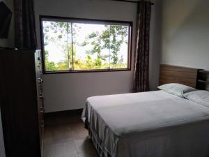 伊利亚贝拉Chalé da Katia的一间卧室设有一张床和一个大窗户