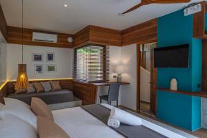 邦劳Bird of Paradise的一间卧室配有一张床、一张沙发和一台电视。