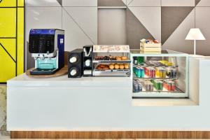 新加坡Holiday Inn Express Singapore Serangoon, an IHG Hotel的配有咖啡壶和开放式冰箱的柜台