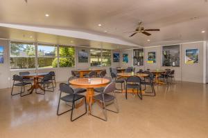 派西亚Riverside Lodge Paihia的用餐室设有桌椅和窗户。