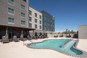 奥德萨Holiday Inn Express & Suites - Odessa I-20, an IHG Hotel的一座带桌椅的大楼前的游泳池