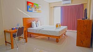 金巴兰Brielle guest house的一间卧室配有一张床、一张书桌和一个窗户。