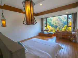 张家界Mount View Cottage的一间卧室设有一张大床和一个大窗户