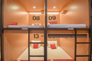 万隆Tokyo Cubo的小房间设有两张双层床,配有红色枕头