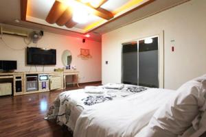大田Motel Nine的卧室配有白色的床和平面电视。