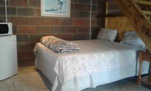 德班Lothian rd Cottage的砖墙房间的一个床位