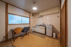 长崎长崎卡盖米亚旅舍的客房设有带桌椅的厨房。