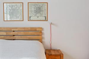 米兰Bed & Breakfast San Calocero - private bathroom - Wi-Fi的卧室配有一张床,墙上有两张地图框