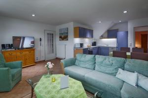 宾茨多米兹欧l宾兹公寓的一间带蓝色沙发的客厅和一间厨房