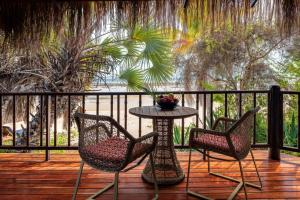 巴扎鲁托巴扎鲁托岛安纳塔拉度假酒店的木甲板上配有两把椅子和一张桌子