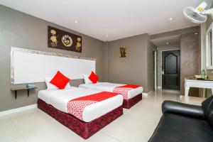 芭堤雅市中心Natural Beach Hotel Pattaya的酒店客房,设有两张床和一张沙发