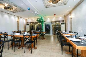 芭堤雅市中心Natural Beach Hotel Pattaya的用餐室配有木桌和椅子