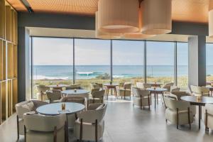 大里贝拉Hotel Verde Mar & SPA的一间带桌椅的海景餐厅