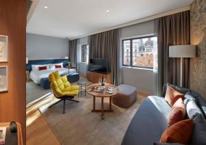 巴塞罗那Mandarin Oriental, Barcelona的酒店客房带起居室,带一张床和一张沙发。