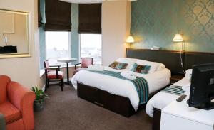 波特拉什艾弗瑞斯特豪斯住宿加早餐酒店的酒店客房设有两张床、一张桌子和一台电视。