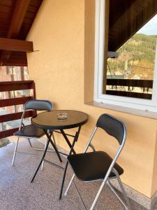 瓦特拉多尔内Pensiunea Casa Alexandra的阳台配有2把椅子和1张桌子