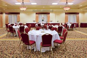 克利尔沃特Holiday Inn & Suites Clearwater Beach, an IHG Hotel的宴会厅配有桌椅和吊灯。