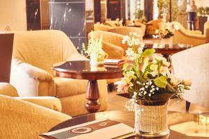特尔古穆列什Continental Forum Tirgu Mures的餐厅配有沙发和鲜花桌