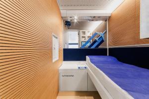 泰塞拉Resting Pods - ZzzleepandGo VCE Venice Airport的小房间设有一张床和蓝色床垫