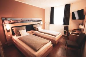 杜塞尔多夫沃格例萨格维格酒店的酒店客房设有两张床和电视。