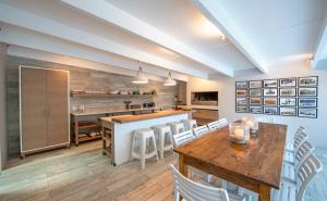 滨海肯顿Driftwood by The Oyster Collection的厨房配有木桌和白色椅子