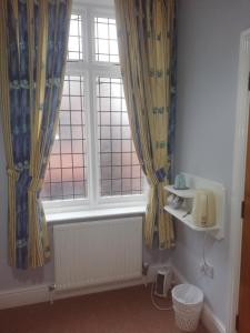 布里格The Lord Nelson的一间带窗帘、水槽和窗户的浴室