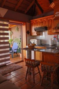 蓬塔戈尔达Casa Fagundo的厨房配有木制橱柜、柜台和椅子