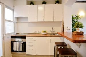 坎皮卡福特Sea House Can Picafort的厨房配有白色橱柜和木制台面